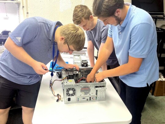 Morgan Ennis, Jacob Lewis and Riley Baldwin are shown working on a computer for Nano Repairs. The three Newcastle High School seniors are interning for the area company. • photo provided