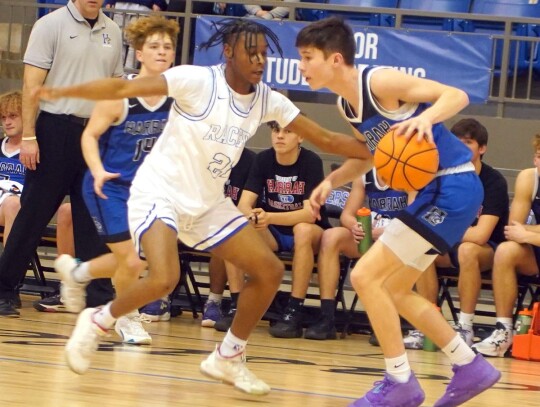 Newcastle’s Jalaun Frazier guards a Harrah ball handler during the Racer’s District-Championship winning game Saturday night at home. photo by Jennifer Lewis