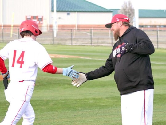 New Newcastle baseball coach Jarod King congratulates one of his players at Comanche last year for a job well done. • courtesy Comanche Times