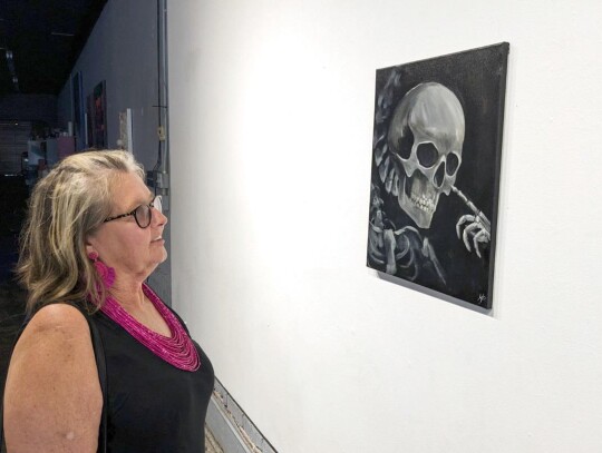 Pictured, from left, at Kristanna Phillips’ art show at Resonator in Norman on Sunday, July 9, are Phillips, her friend Emma Wilson, and Kristana’s niece, Nevaeh Quinn Phillips. Teresa Shepherd (photo right), a NHS paraprofessional, looks over some of