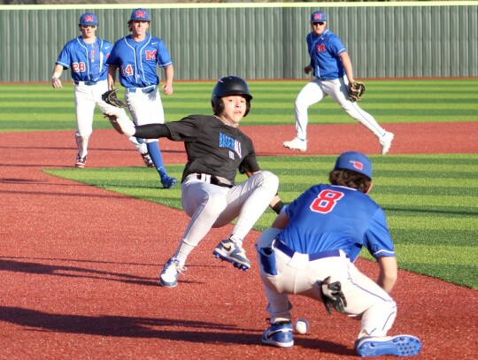 Kaden Longman gets into a hotbox between second and third bases in the preseason Moore game. • photo by Lisa Longman-Smith