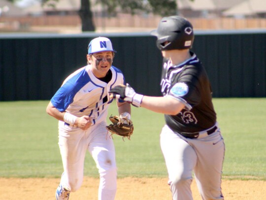 Gunner King runs down a base runner during the season opener. • photo by Lisa Longman-Smith