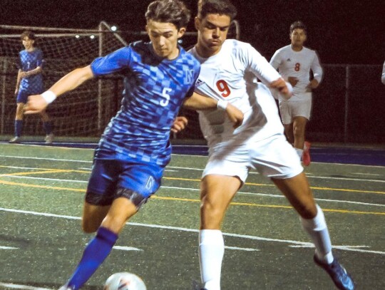 Toby Batchelder fights for possession for the Racers. • photo by Mindi Stucks