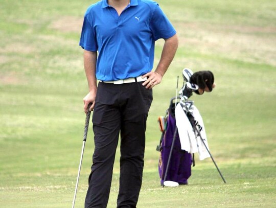 Evan Goold takes a look at his putt while waiting his turn at the Conference Tournament. • photo by Valerie Dobbs